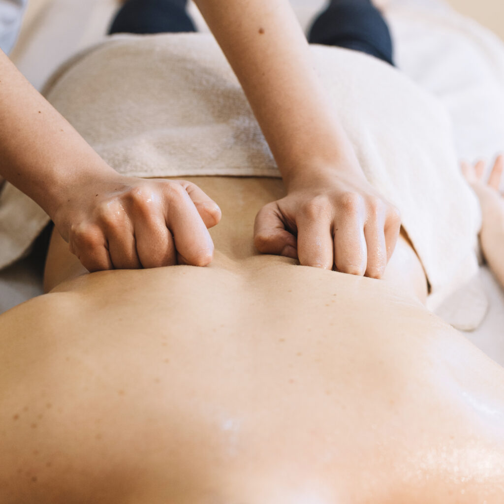Hände bei einer Massage im Rückenbereich
