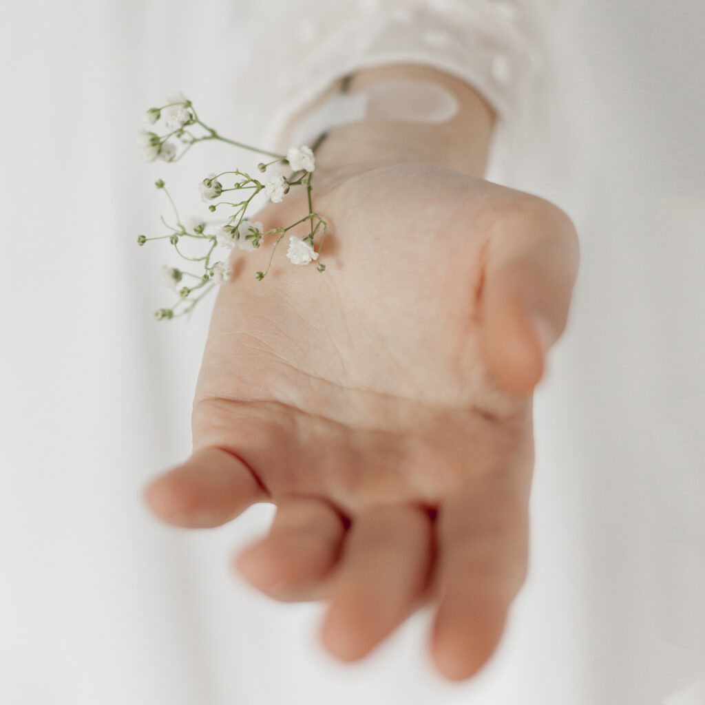 Geöffnete Hand mit kleinen weißen Blüten