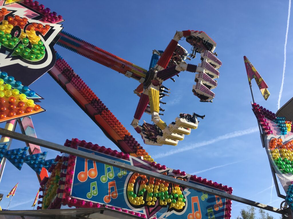 Fahrgeschäft auf einem Jahrmarkt vor blauem Himmel